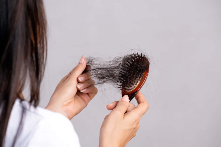 Healthy concept. Woman show her brush with damaged long loss hair and looking at her hair